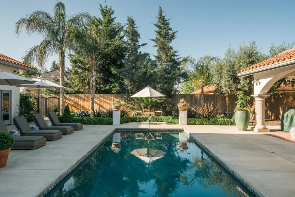 Traditional pool area with lounge chairs and palm trees